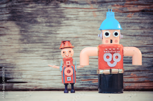 Assemblage daddy and son robot sculptures, wood background