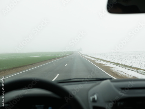 Driving in foggy weather. foggy road. bad weather at the wheel, foggy foggy country road. dangerous road. view from the drivers seat