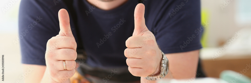 Smiling worker in yellow helmet show confirm sign with thumb up at arm portrait. Manual job DIY inspiration joinery startup idea fix shop hard hat industrial education profession career concept Smiling worker in yellow helmet show confirm sign with thumb up at arm portrait. Manual job DIY inspiration joinery startup idea fix shop hard hat industrial education profession career concept