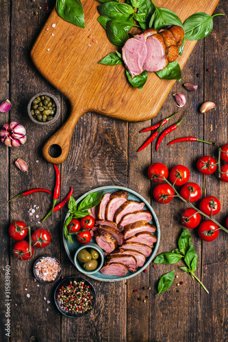 Smoked roasted goose carpaccio on wooden table with garnish green salad