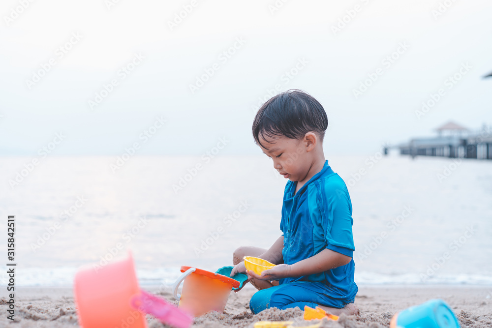 A boy is playing sand and swimming with his brother on the beach. A boy is playing sand and swimming with his brother on the beach.