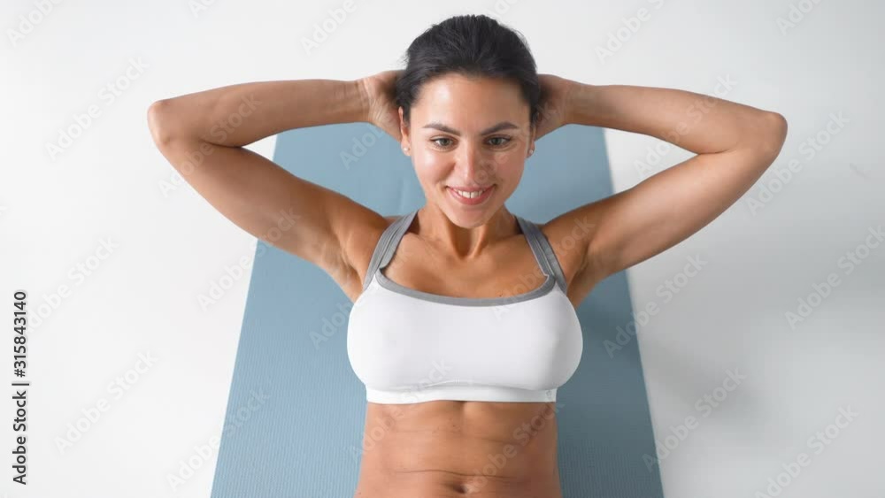 close-up video of woman doing abdominal exercise indoors.