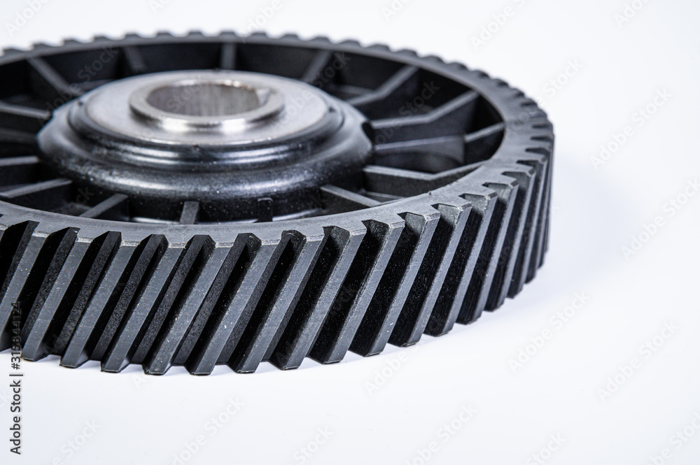 Black polymer gear camshaft with metal base. New spare part for an internal combustion engine on a gray background Black polymer gear camshaft with metal base. New spare part for an internal combustion engine on a gray background