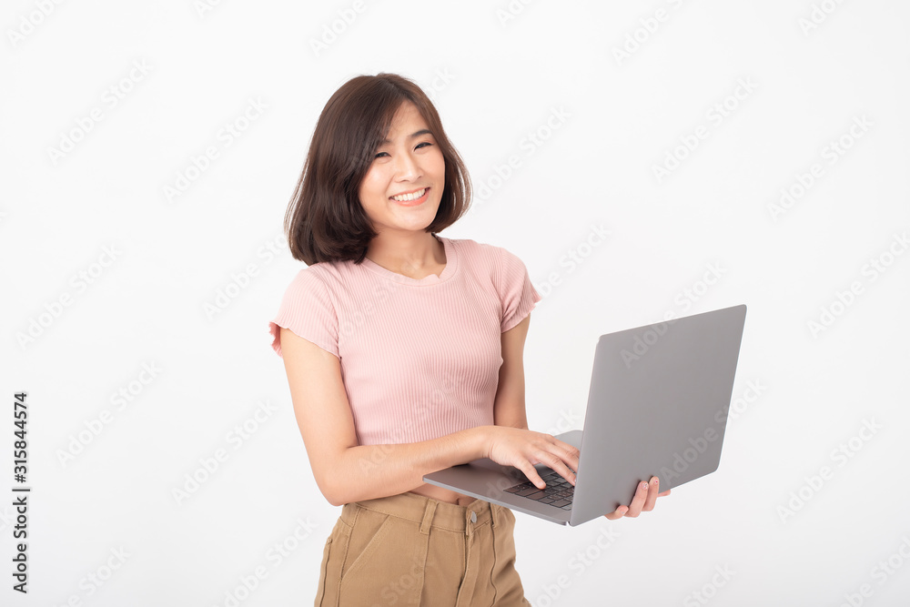 Cute Asian teen woman is working with computer on white background Cute Asian teen woman is working with computer on white background
