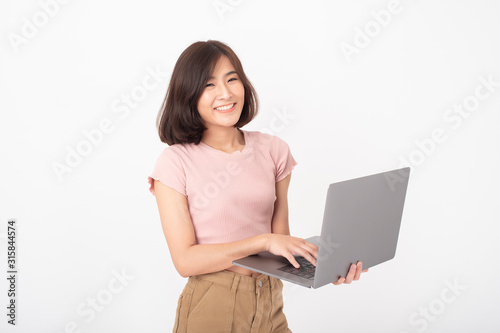 Cute Asian teen woman is working with computer on white background