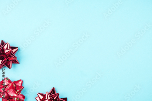 Gift red bows on a blue background. The concept of the celebration and gifts