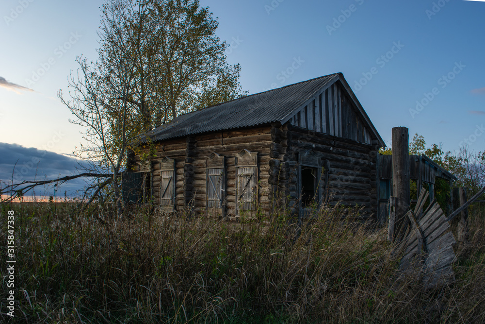abandoned house with broken windows and a fallen gate in a field abandoned house with broken windows and a fallen gate in a field