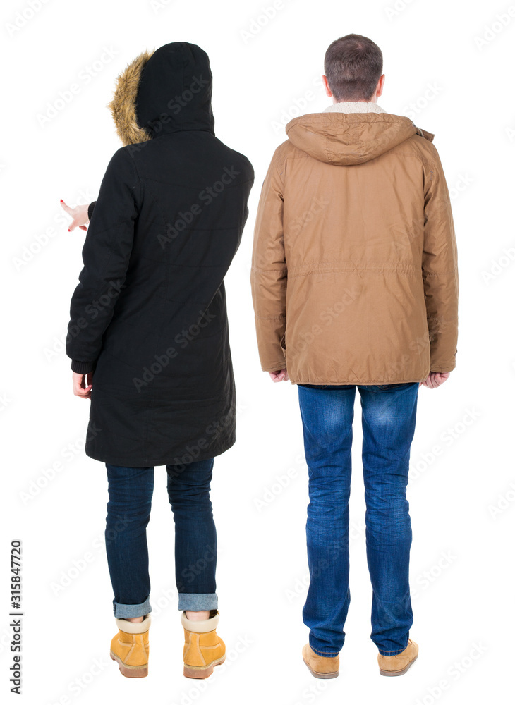 Back view of couple couple in winter jackets pointing. Back view of couple couple in winter jackets pointing.