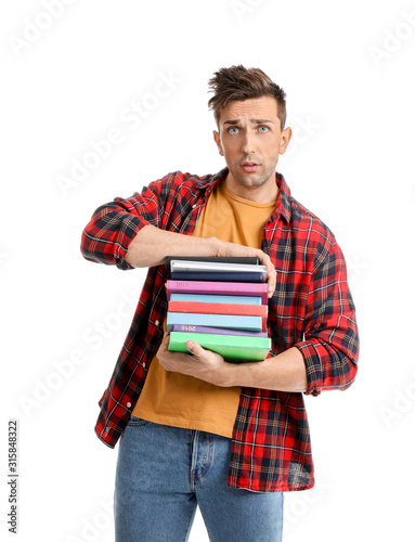 Sad young man with books on...