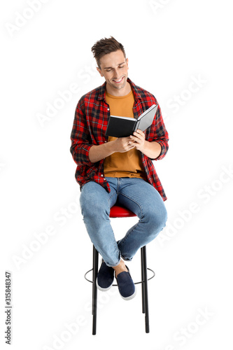 Handsome young man reading ...