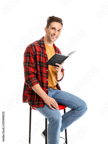 Handsome young man reading ...