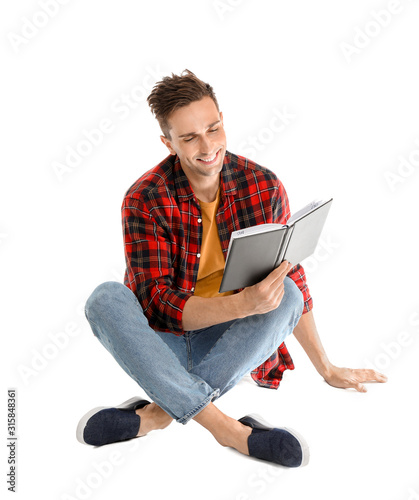 Handsome young man reading ...