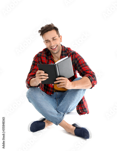 Handsome young man reading ...