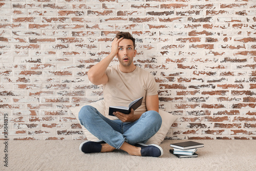 Shocked young man with book...