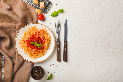 Plate with tasty pasta and tomato sauce on white background