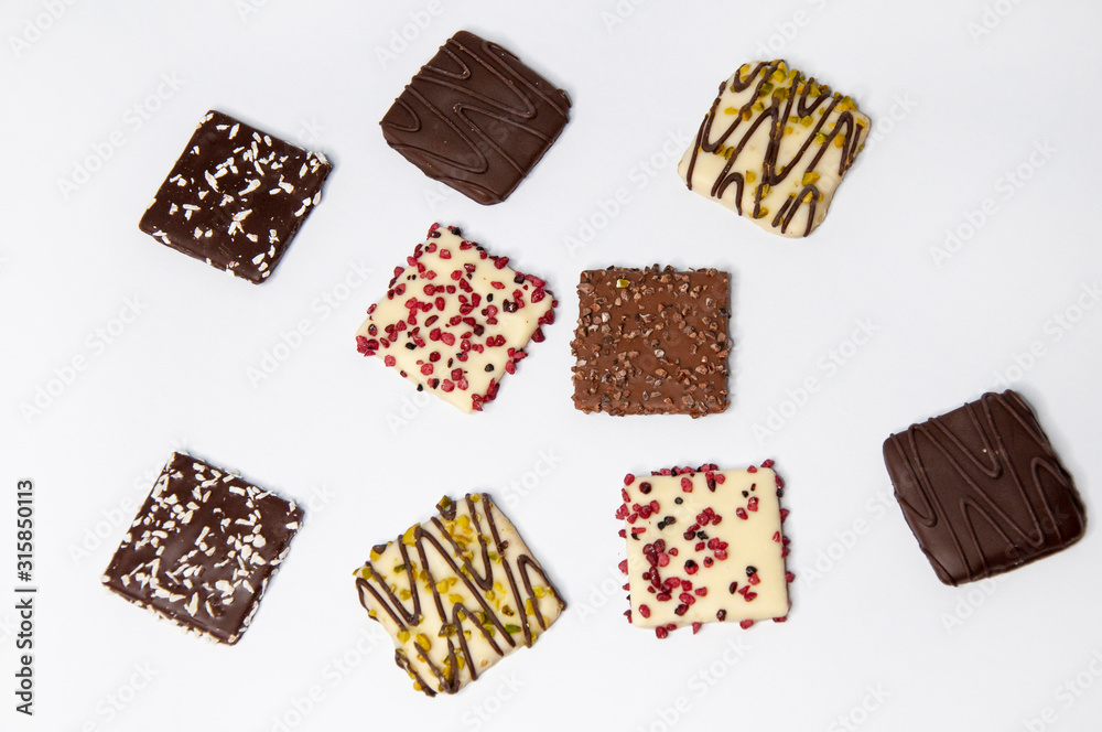 Many beautiful multi-colored cookies in chocolate on a white background
