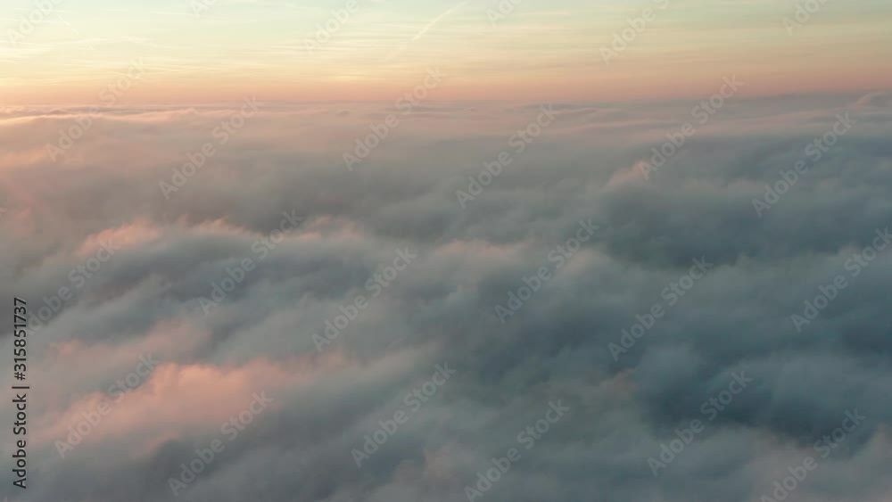 Flying sideways above the clouds with a beautiful sunset and sky