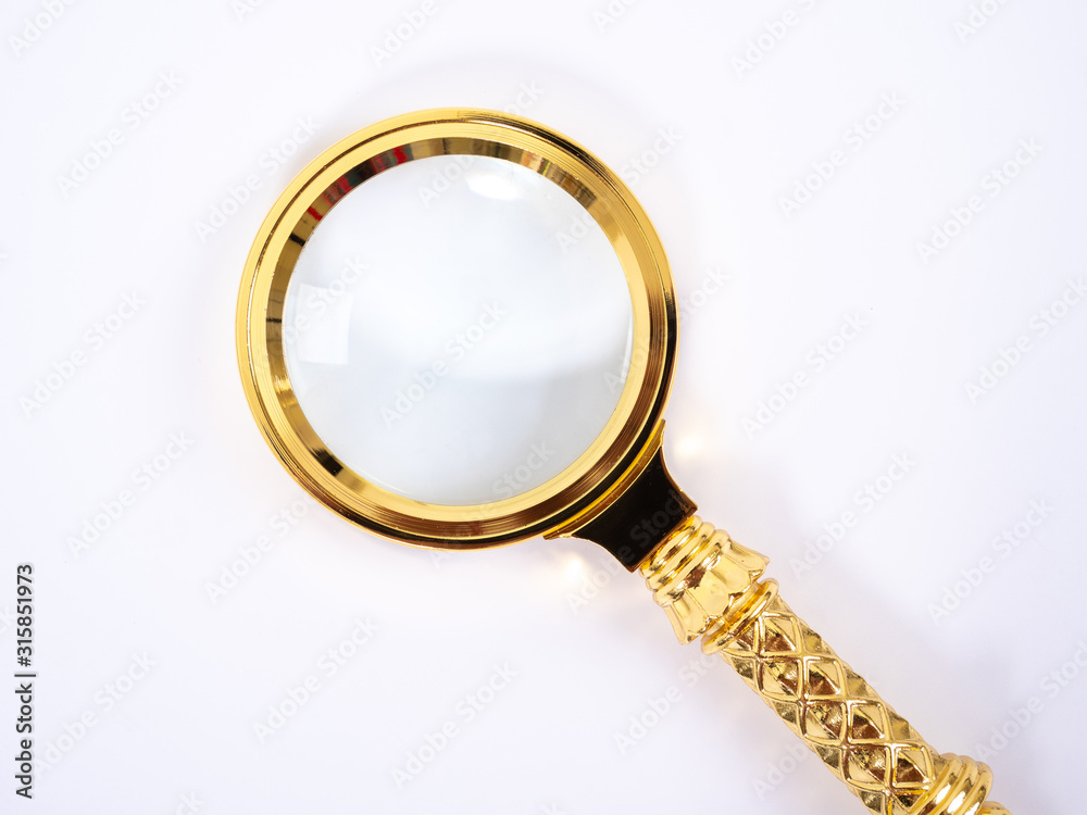 Small Gold Magnifying Glass Isolated on a White Background. Small Gold Magnifying Glass Isolated on a White Background.