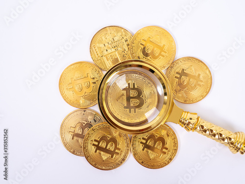Golden bitcoin magnifying glass on a blurred background of coins