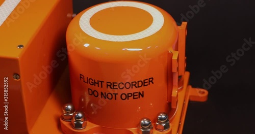 Aircraft flight data recorder on black background.