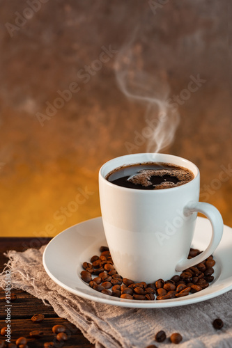 White coffee cup and coffee beans on wooden background