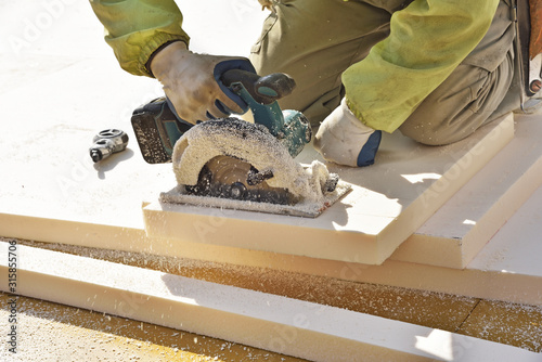 Carpenter using circular saw: cutting heat insulating 