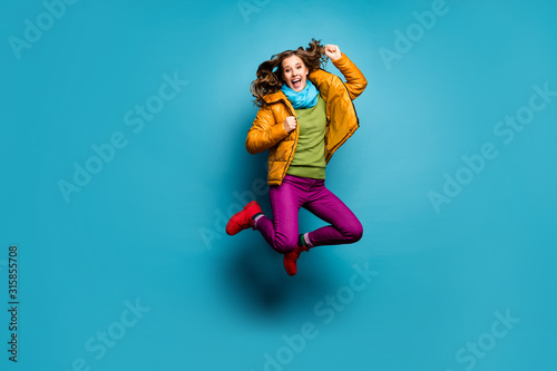 Full body photo of pretty lady jump high up celebrating amazing achievement wear casual yellow overcoat scarf violet pants red boots green pullover isolated blue color background