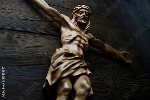  Cruciefied Jesus figure isolated on rustic dark brown table. photo