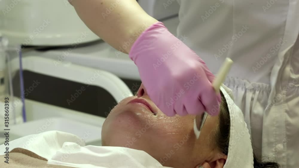 A woman is preparing for a laser rejuvenation procedure in the salon A woman is preparing for a laser rejuvenation procedure in the salon