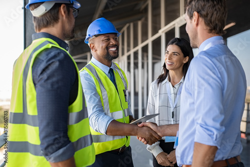 Engineer and businessman handshake at construction site photo