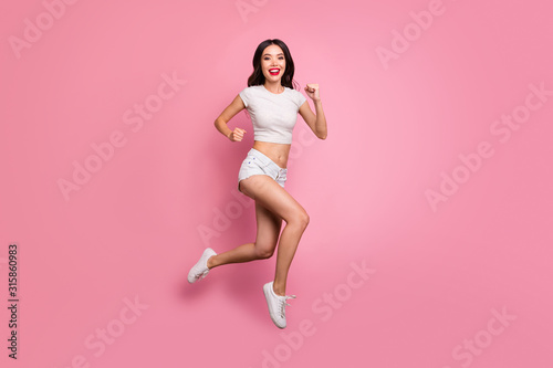 Full length body size view of her she nice attractive lovely charming sportive cheerful cheery wavy-haired girl jumping running having fun motion isolated over pink pastel color background