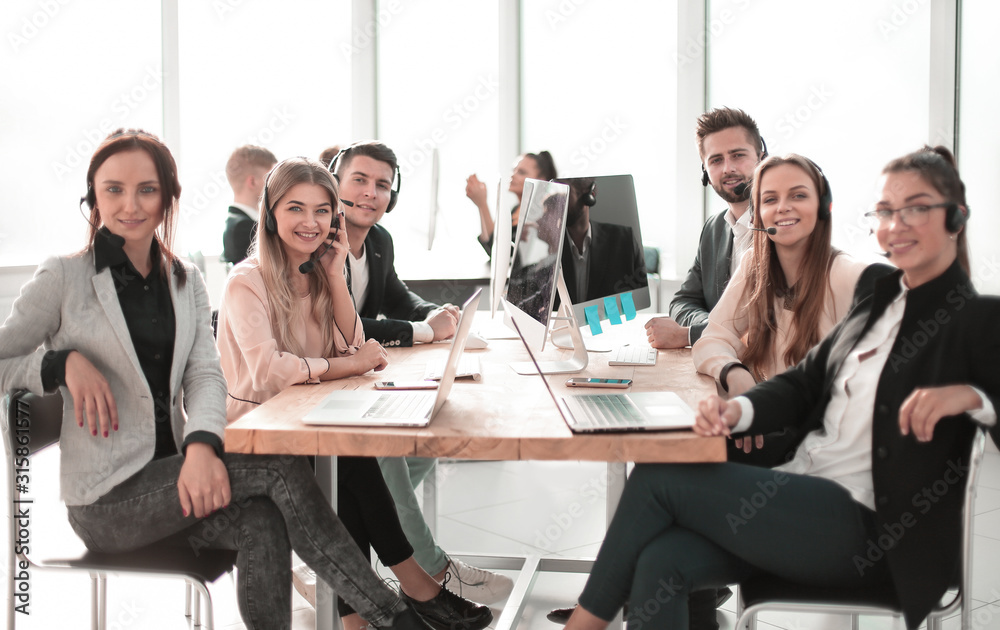 group of employees with a headset sitting at a Desk. group of employees with a headset sitting at a Desk.