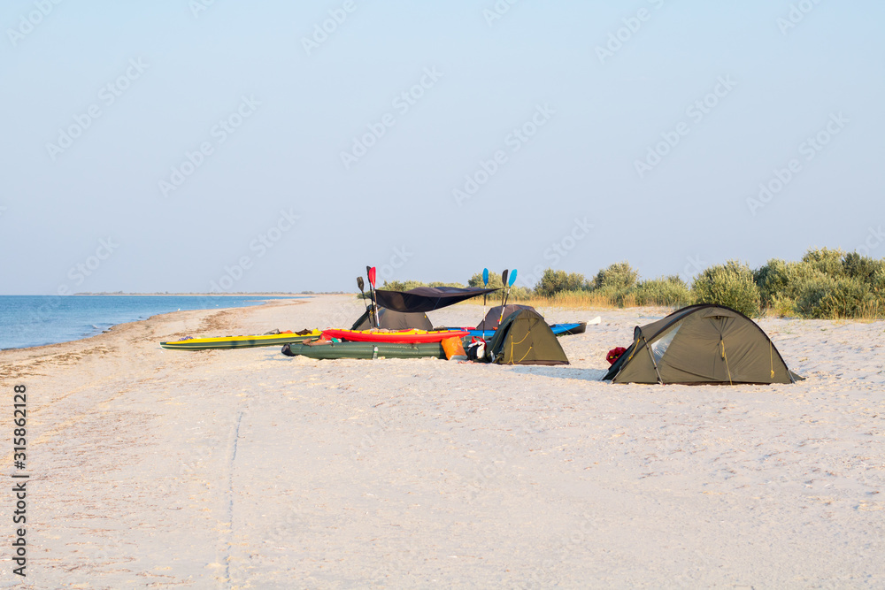 expedition camp with tents and kayaks on the beach expedition camp with tents and kayaks on the beach