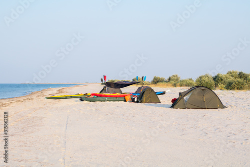 expedition camp with tents and kayaks on the beach