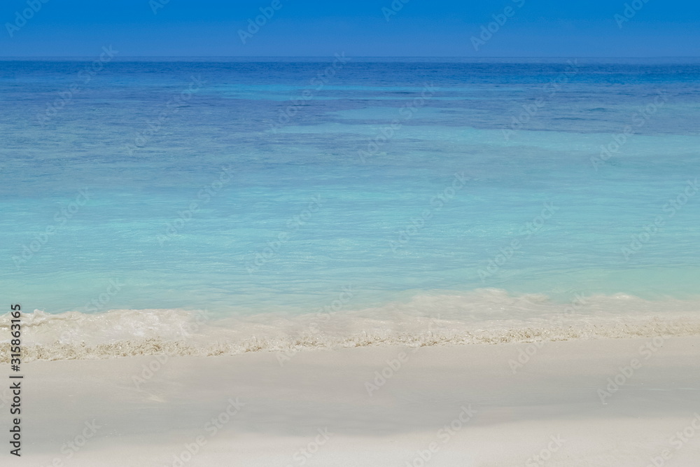 Fototapeta premium view of soft wave in blue-green sea with blue sky background, Tachai island, Mu Ko Similan National Park, Phang Nga, south of Thailand.