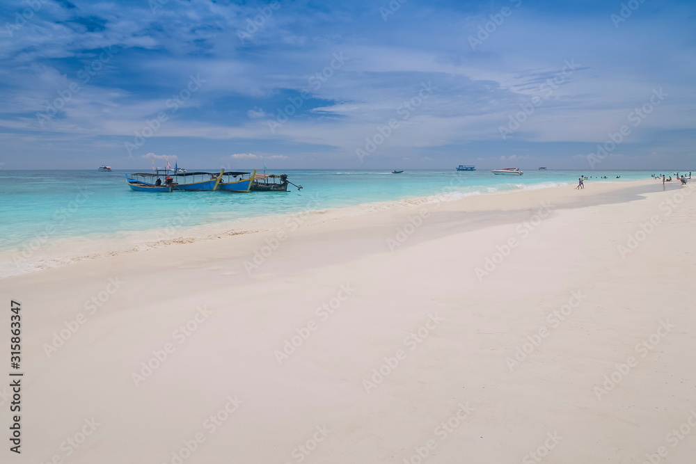 view of long beach with blue- green sea and cloudy sky background,  Tachai island, Mu Ko Similan National Park, Phang Nga, south of Thailand.