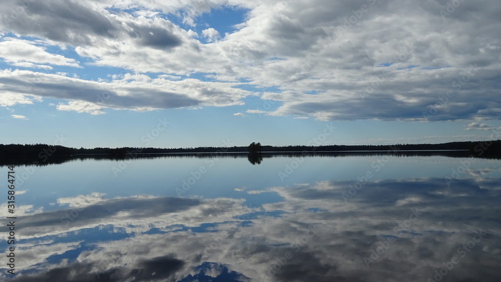 Mirroring clouds over a lake on a wind still afternoon 