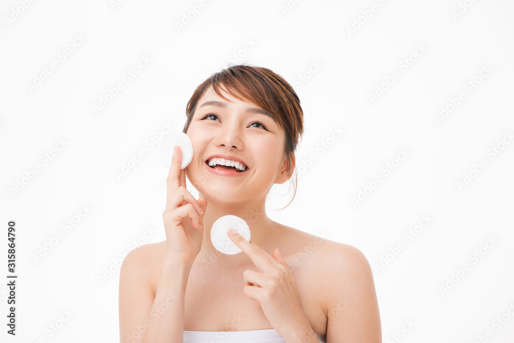 Beautiful young woman cleaning her face with cotton Beautiful young woman cleaning her face with cotton