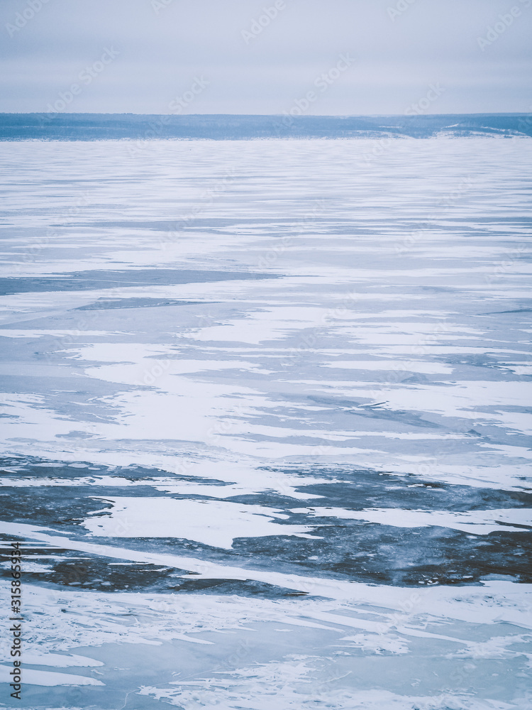 Ice landscape, endless panorama of the ice surface on the frozen river