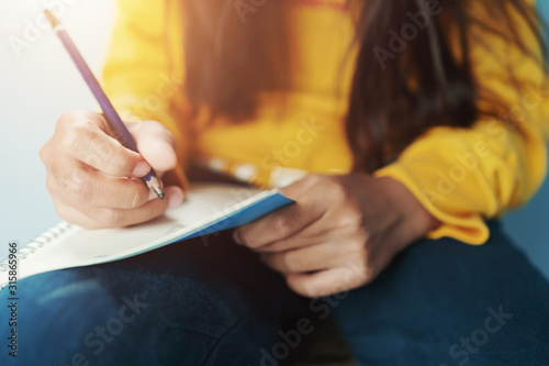 children writing on notebook by pencil