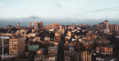 Photo of brown houses in the city with the help of a drone. Cloudy autumnal cozy city with houses and buildings in brown tones. © Andrii Chagovets