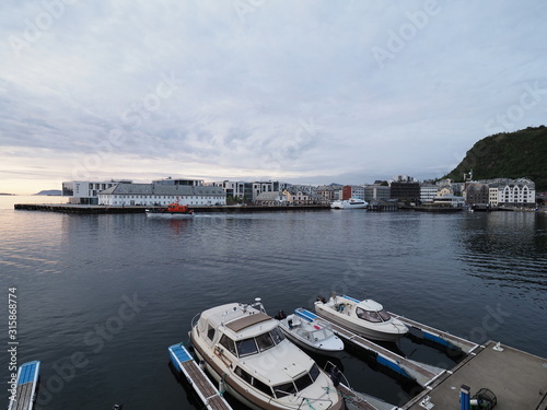 White motorboats in port of european Alesund town at Romsdal region in Norway