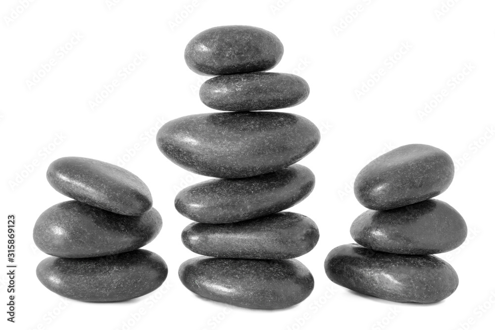Stacked natural smooth grey stones in zen balance isolated on white background. Stacked natural smooth grey stones in zen balance isolated on white background.