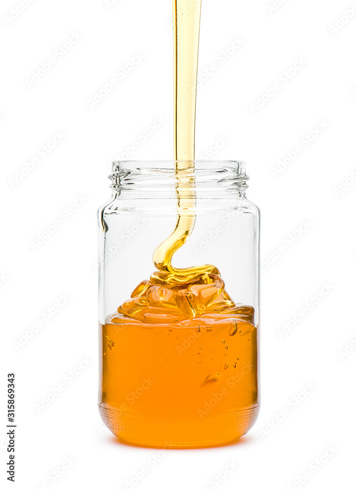 Honey spilling in glass jar, on white background Honey spilling in glass jar, on white background
