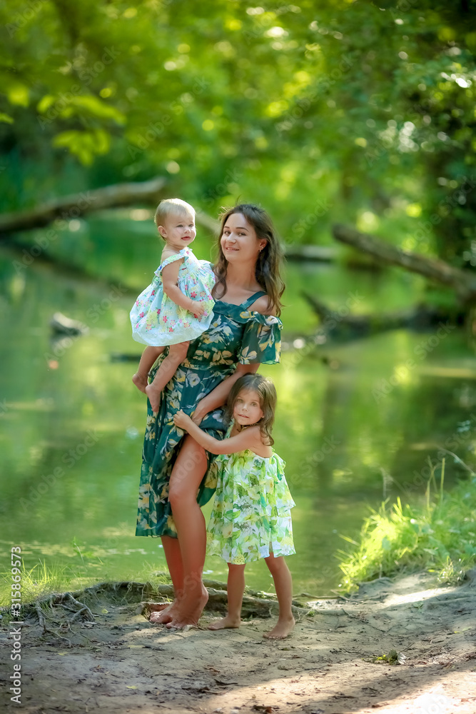 Mom with little daughter on a summer walk near the water in the forest. Mom with little daughter on a summer walk near the water in the forest.