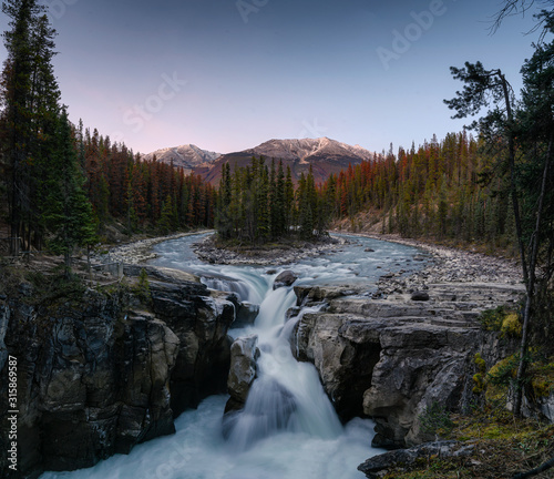 Sunwapta Falls is pair of the Sunwapta river in autumn forest at sunset