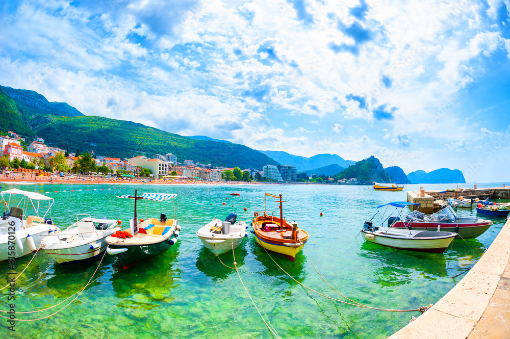 Port with boats and beautiful beach in Petrovac, Montenegro. Summer landscape, sea view. Famous travel destination