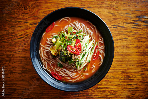 Korean soba noodle with leaf vegetable with spicy soup  photo