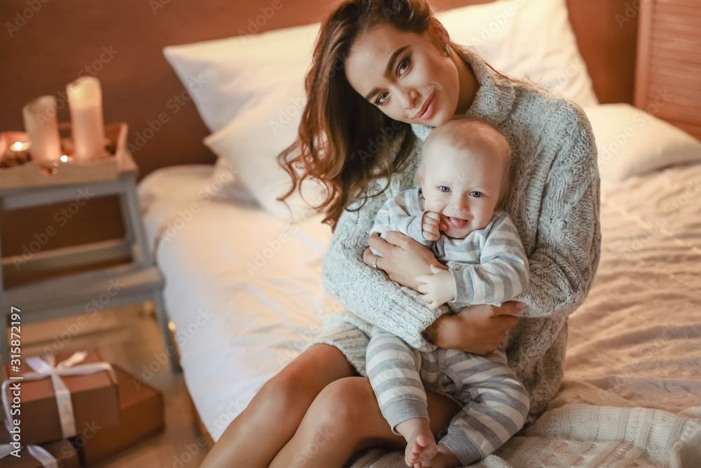 Mom and son baby in pajamas play and indulge in the room. Mom and son baby in pajamas play and indulge in the room.
