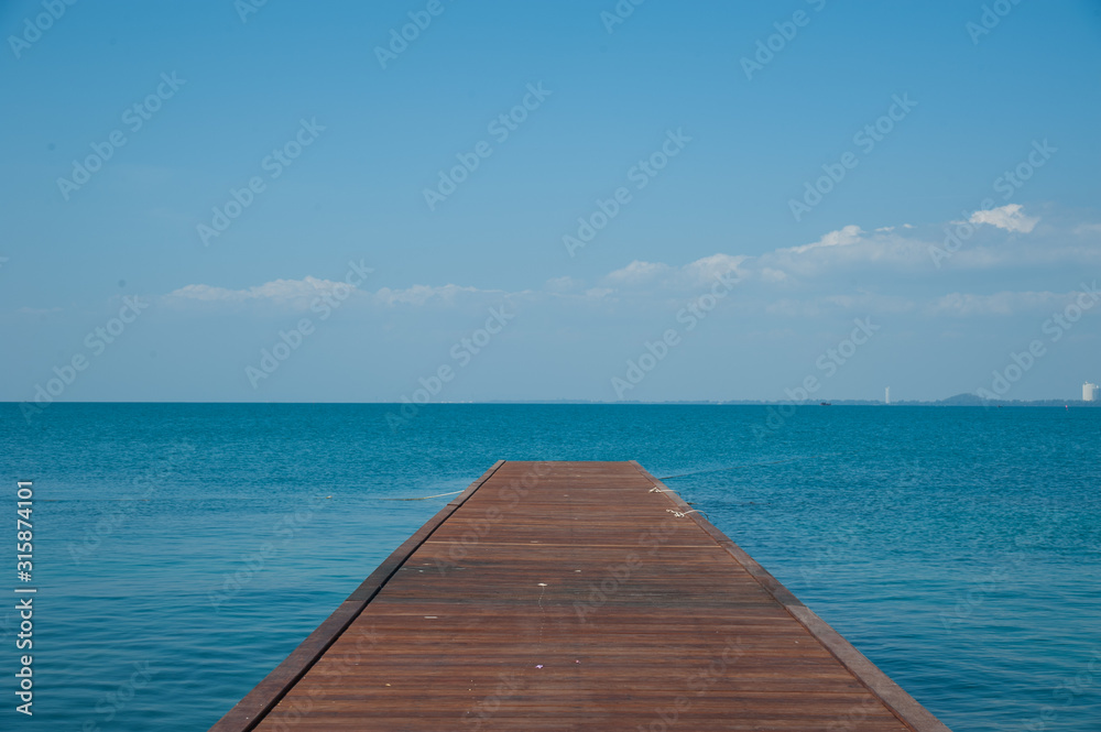 Wood bridge on the sea and blue sky. 